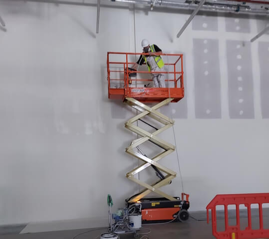 spraying a wall at a tv studio